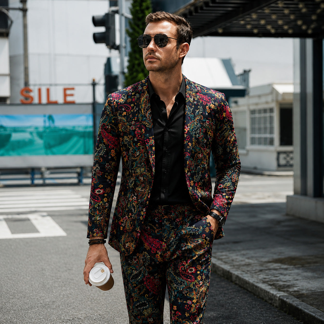 Men's artistic dark paisley suit jacket and matching trousers paired with a black button-up shirt and sunglasses walking on an urban street.