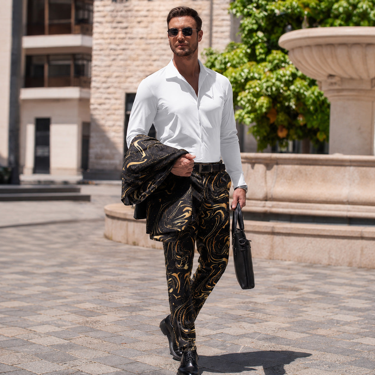 Man walking outdoors in a white dress shirt and black and gold marble print trousers holding a blazer