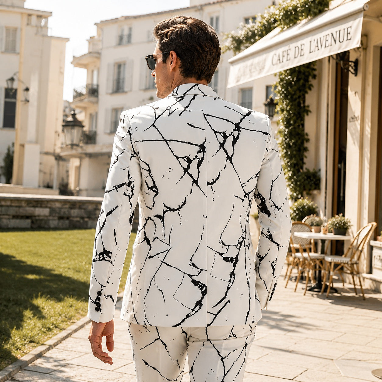 Back view of a slim fit white men's suit jacket featuring a bold black marble pattern design walking down a classic street.