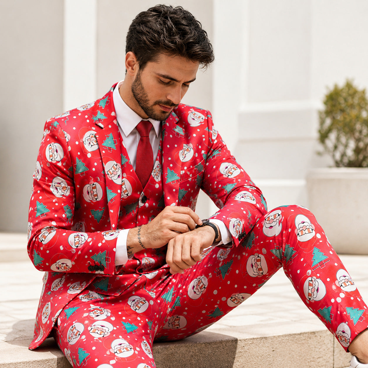 Man sitting outdoors wearing a red Santa print party suit with red tie by WISHOLIC