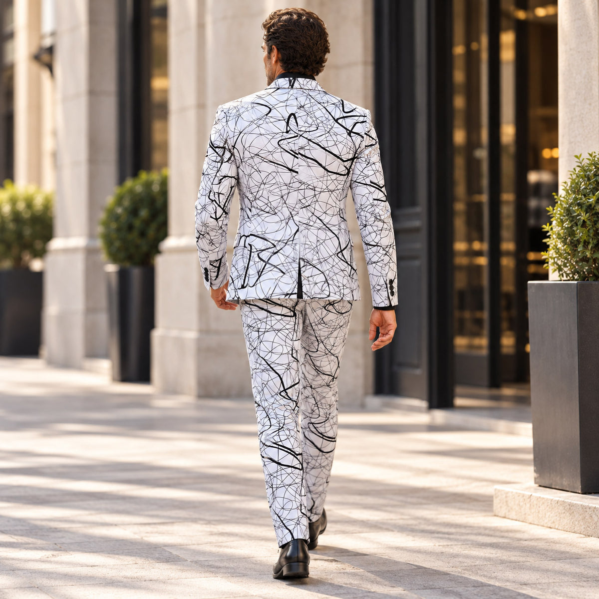 Back view of the Wisholic tailored abstract scribble print blazer and slim-fit trousers walking outdoors[cite: 44]