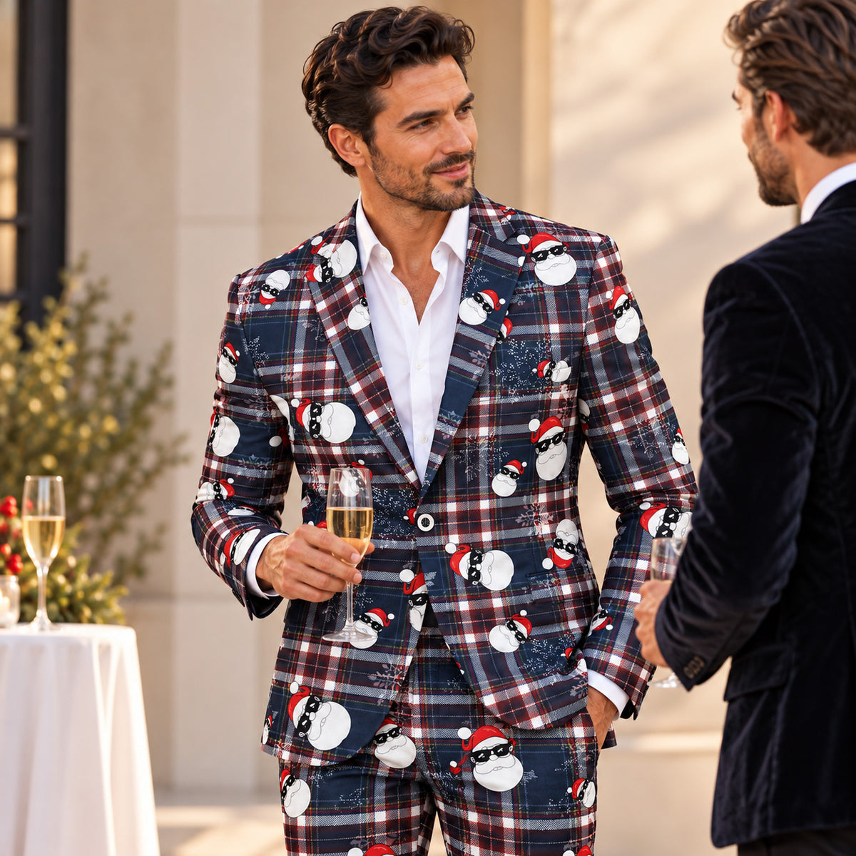 Man wearing Wisholic Christmas plaid suit holding a champagne glass at a holiday cocktail party with friends.