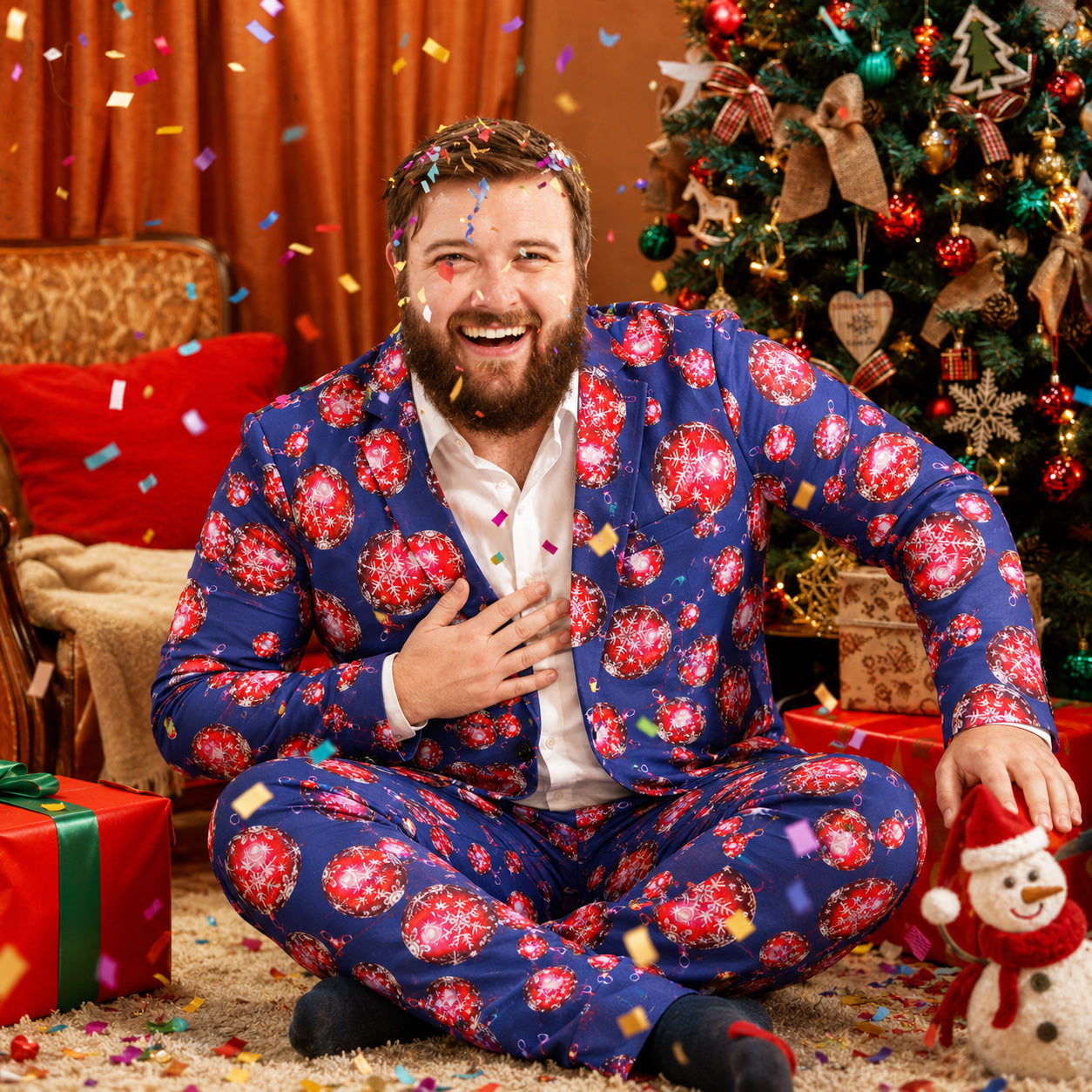 Happy man in Wisholic blue Christmas pattern suit sitting with confetti and snowman at holiday celebration