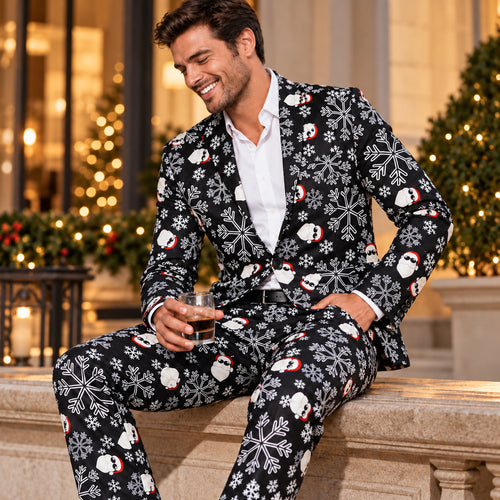 Model wearing Wisholic black festive holiday suit printed with sunglasses Santa Claus and snowflakes, sitting casually with a drink.