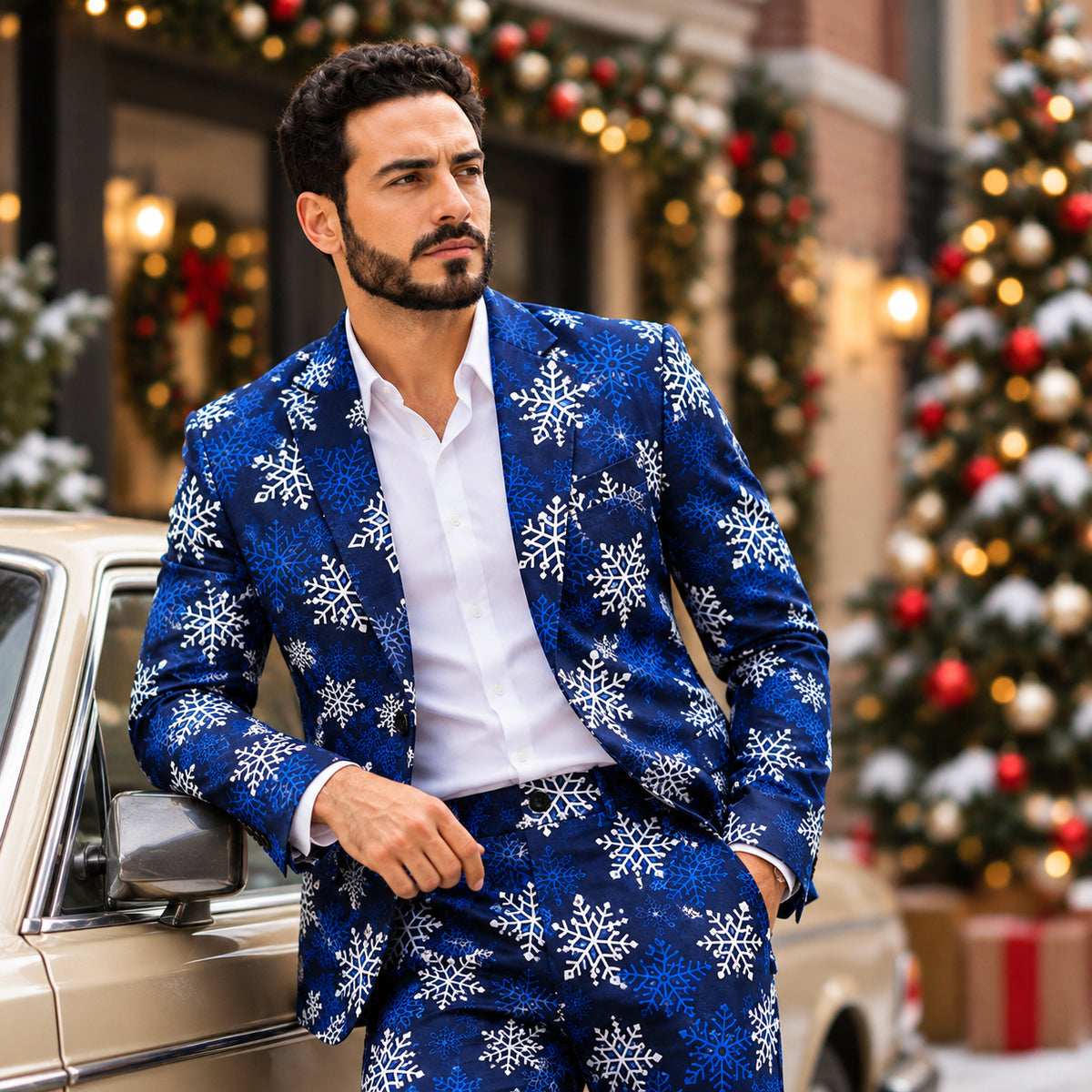 Stylish man wearing Wisholic blue snowflake Christmas suit leaning against a vintage car with holiday decorations.