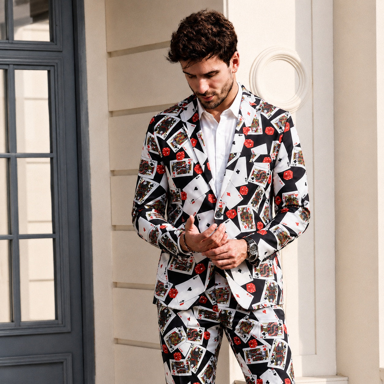 Close-up of a man wearing Wisholic playing card print suit with a white shirt in front of a classic building.